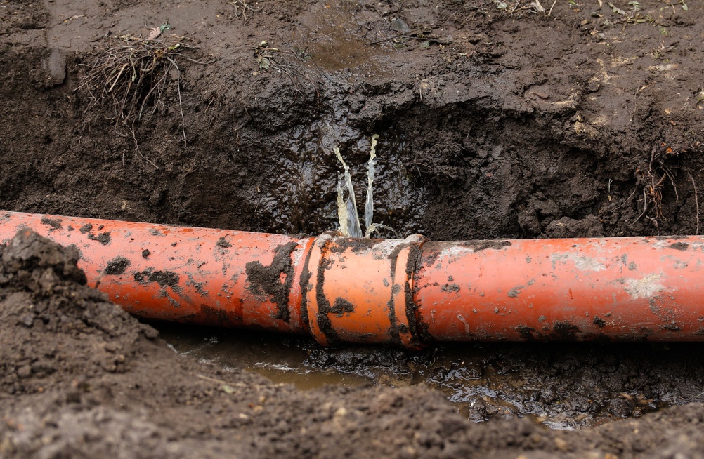 Homeowner checking for hidden plumbing leaks after receiving a high water bill in a residential property