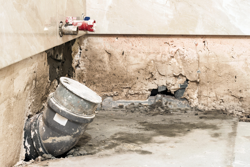 Professional plumber identifying plumbing mistakes during remodeling in a residential home